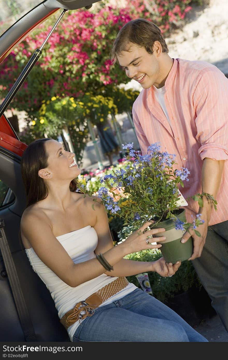 Couple with potted flower in garden centre