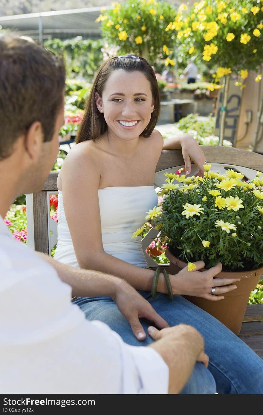 Young couple sitting on bench in garden