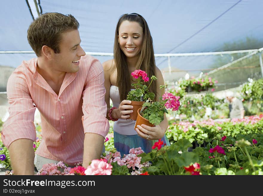 Young couple choosing potted flowers