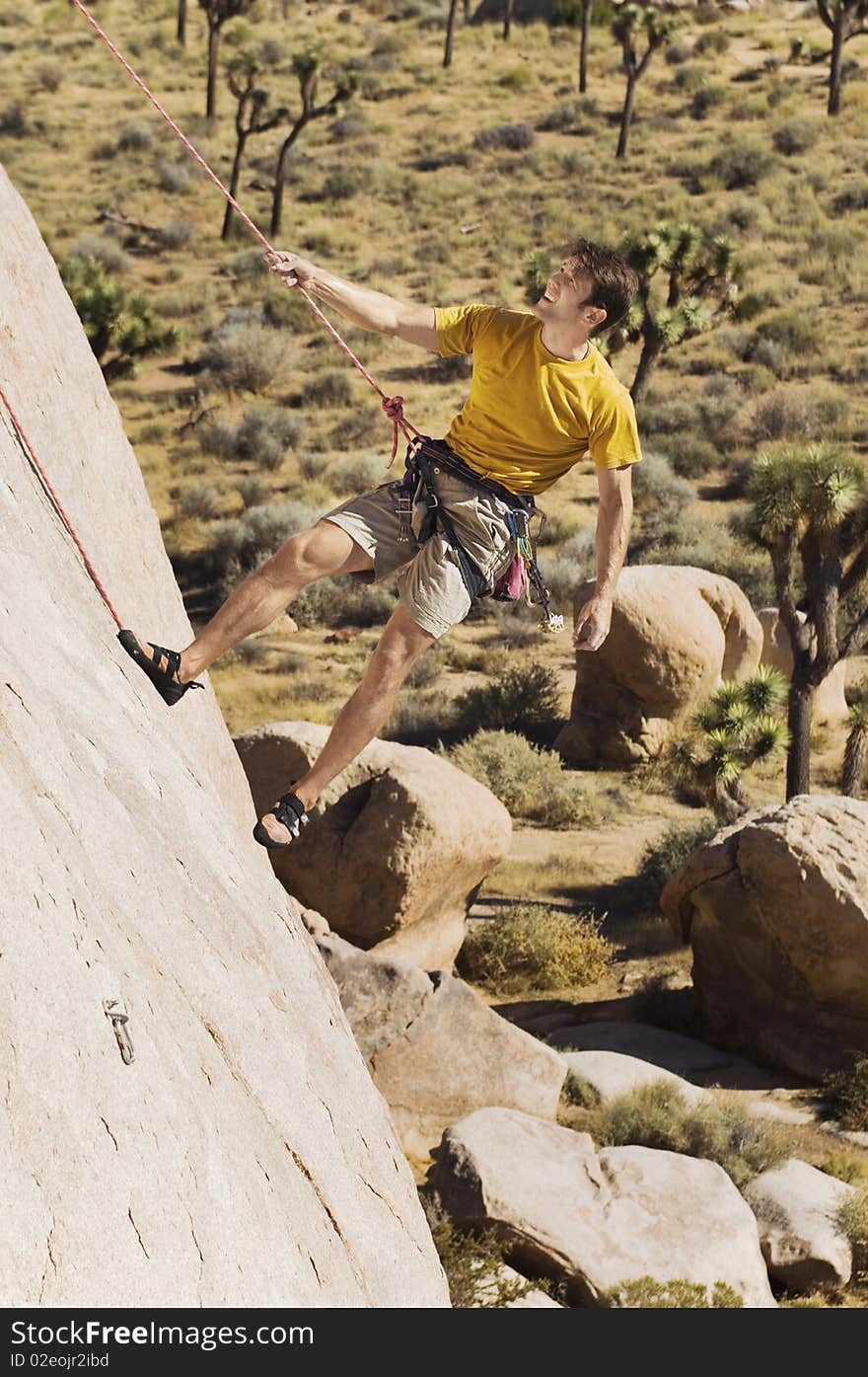 Climber Tugging on Rope on Cliff