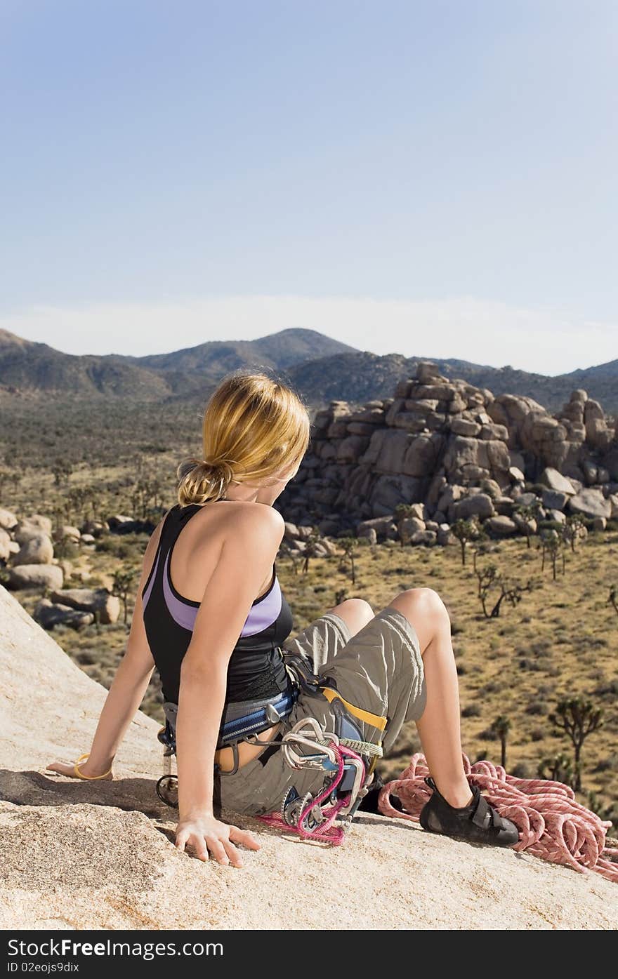 Female Climber on Rock Looking at Desert