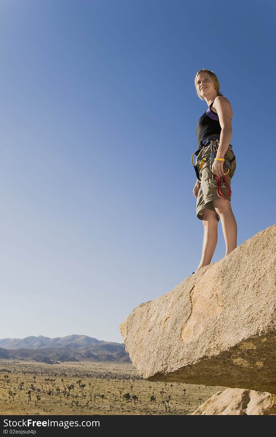 Climber Standing On Rock Looking At Desert