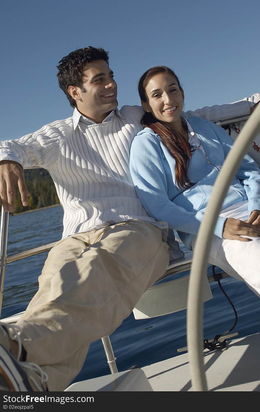 Young couple sitting on sailboat