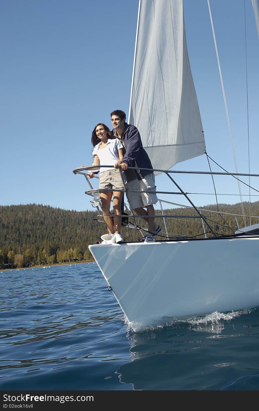 Young couple standing on sailboat