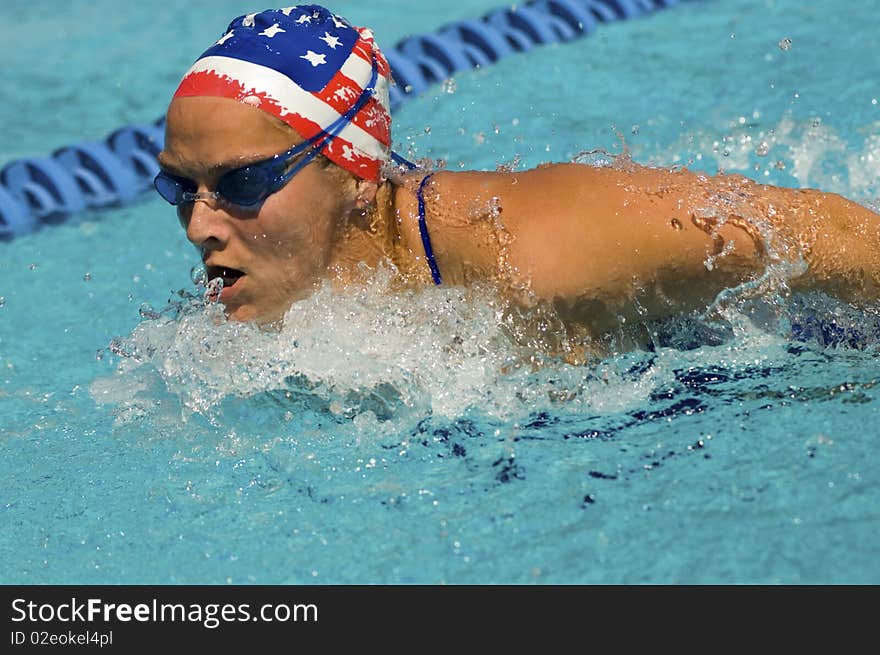 Woman swimming butterfly stroke, (close-up)