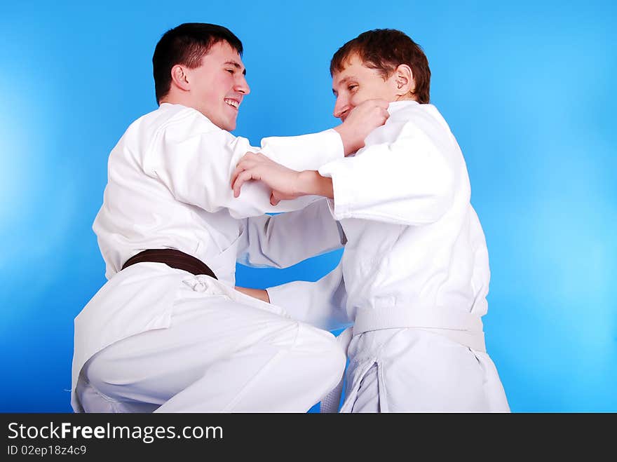 Two karatekas on a dark blue background. Two karatekas on a dark blue background.