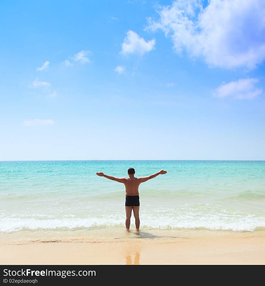 Relaxed young man with his hands stretched, standing at the beach. Relaxed young man with his hands stretched, standing at the beach