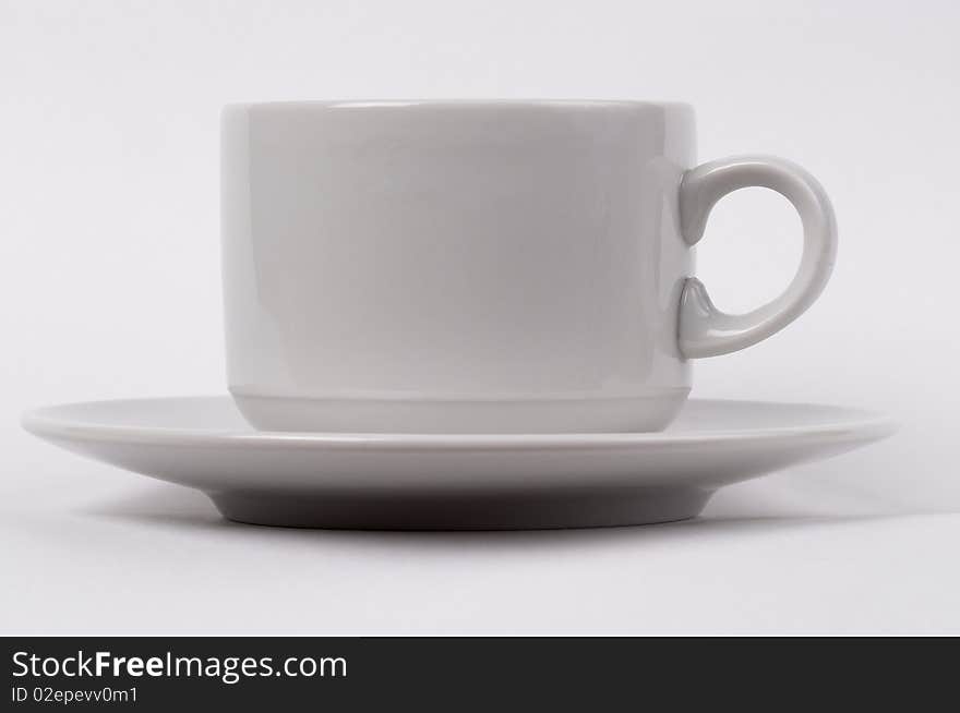 Little white tea cup isolated over grey gradient background