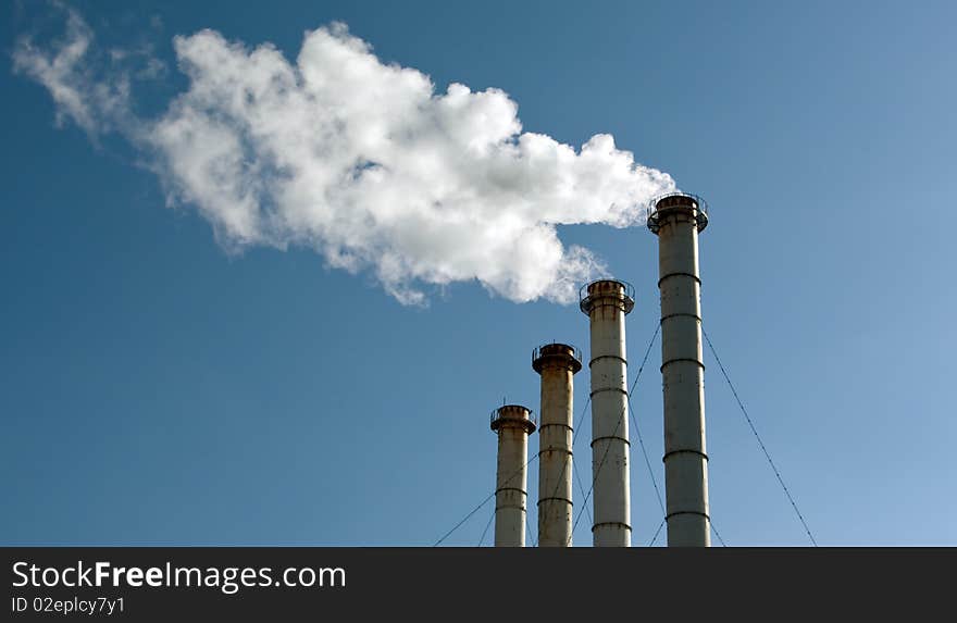 Industrial exhaust pipes on dark-blue sky background