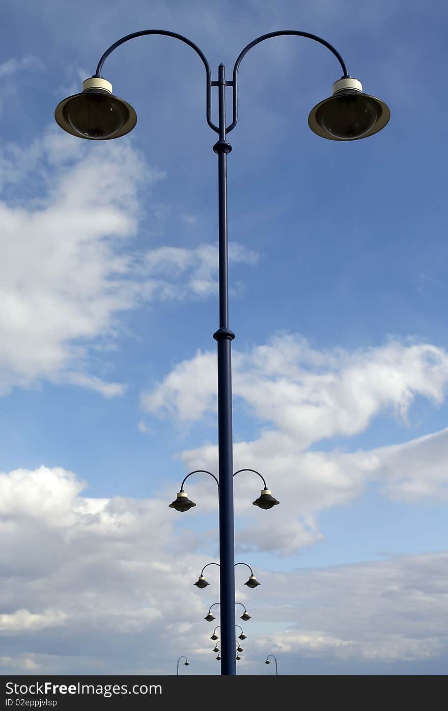 Lamps line beneth the blue sky.