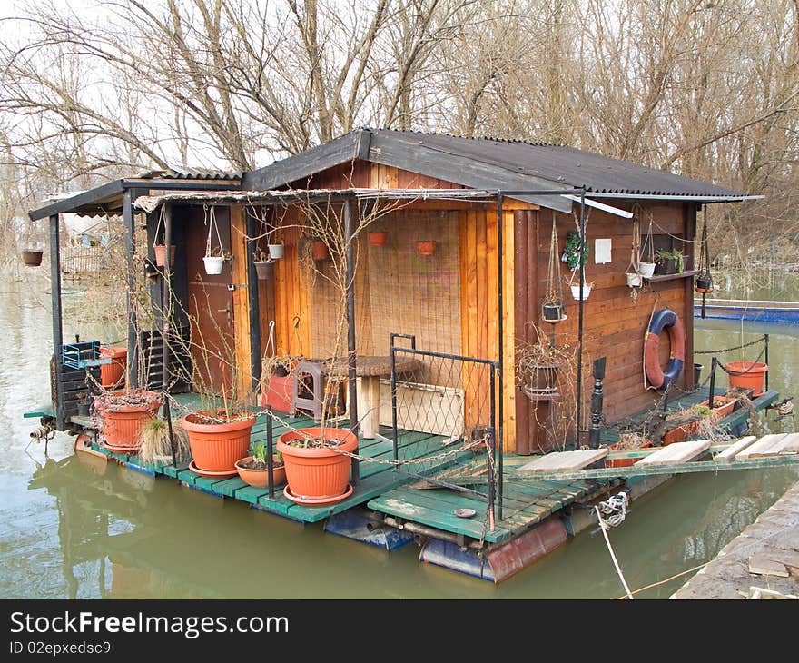 Wooden raft house cottage on river in winter time. Wooden raft house cottage on river in winter time