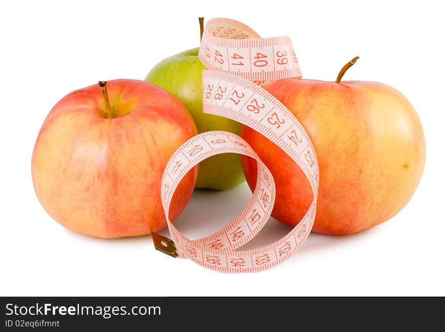 Pink measuring tape and three apples on a white background