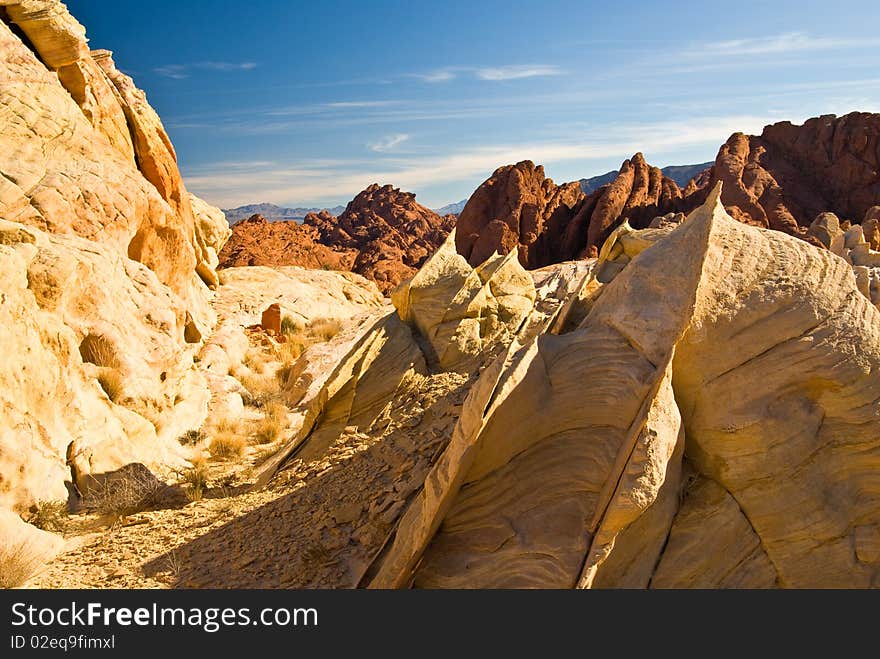 Rugged red sandstone outcropping in late day light with blue sky and clouds. Rugged red sandstone outcropping in late day light with blue sky and clouds