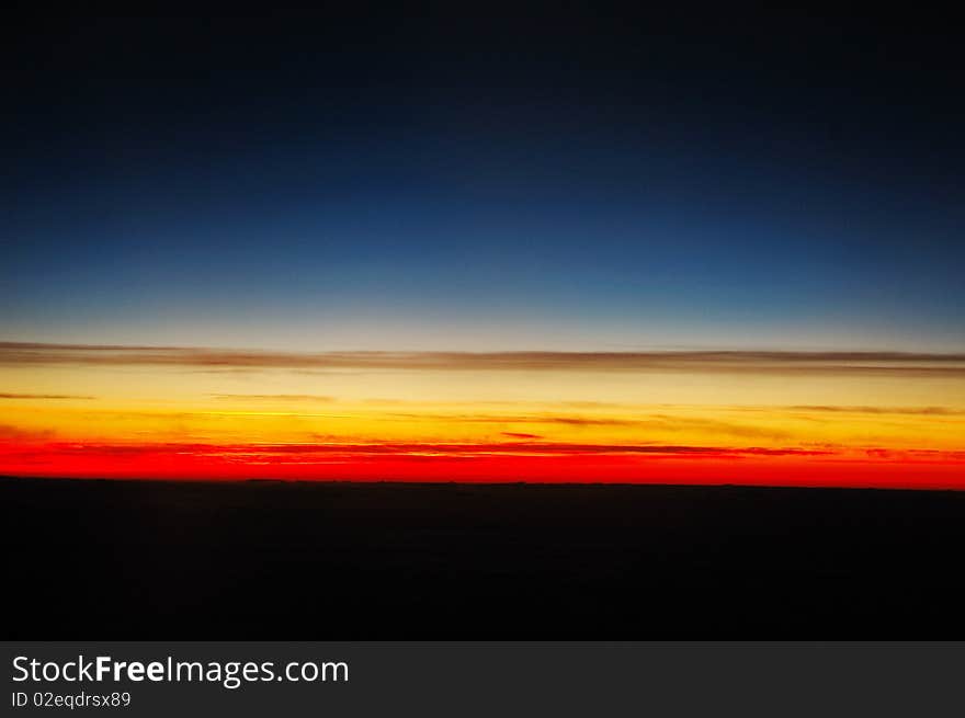 Beautiful and corourful sunset above clouds, shot taken from plane