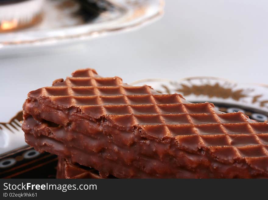 In the foreground a wafer in chocolate - an easy dessert. In the foreground a wafer in chocolate - an easy dessert.