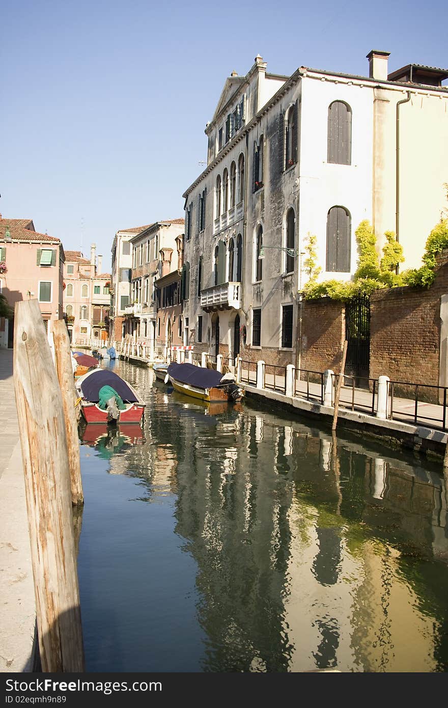 Boats at venetian canal among old and multicolored houses in (Grand canal, Venice, Italy). Boats at venetian canal among old and multicolored houses in (Grand canal, Venice, Italy)