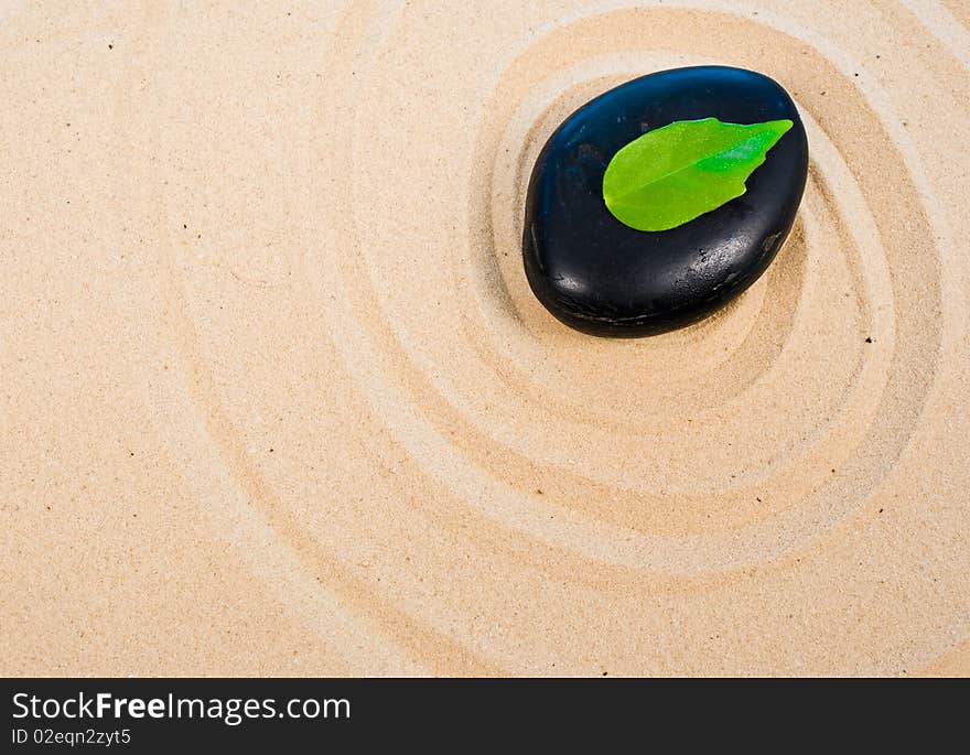 Zen stone, leaf on sand