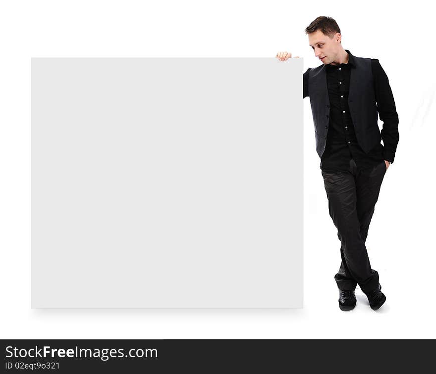 Young attractive man standing and holding white banner for your text or picture