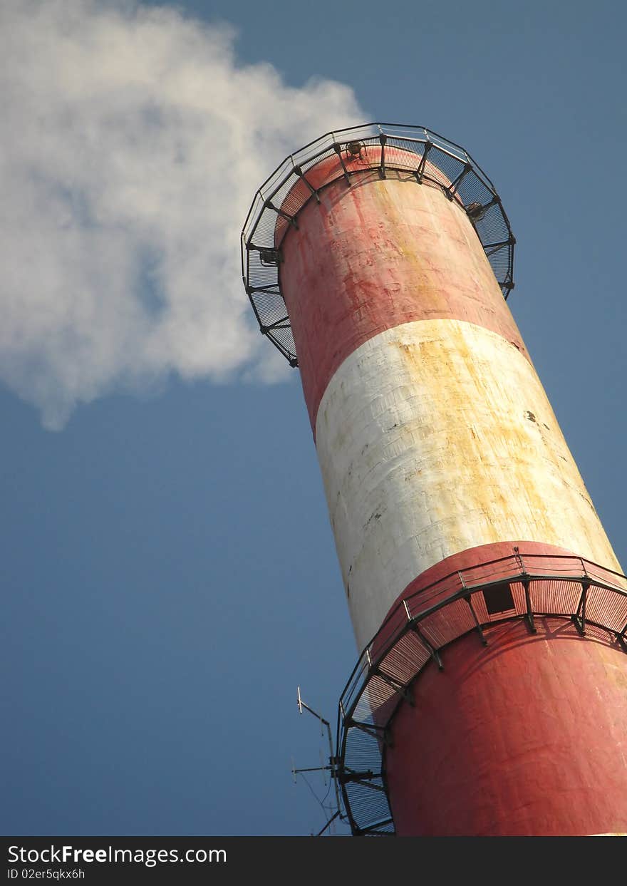 Old tall chimney painted white with red