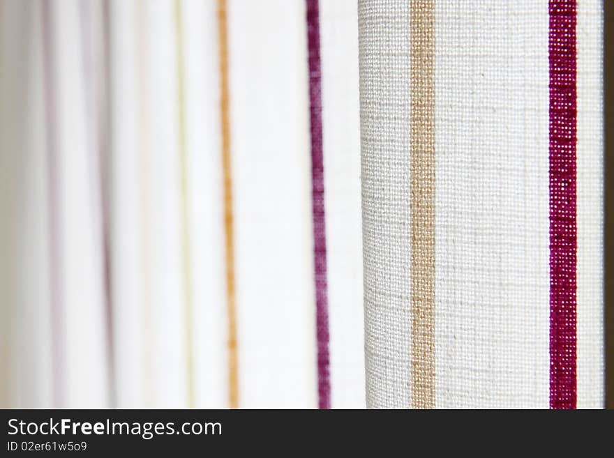 White curtain with yellow and purple stripe in a room