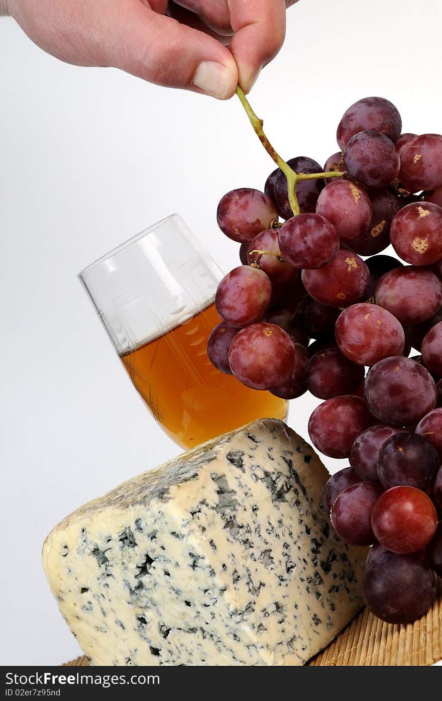 Human Hand Taking Moldy Cheese And Red Grapes