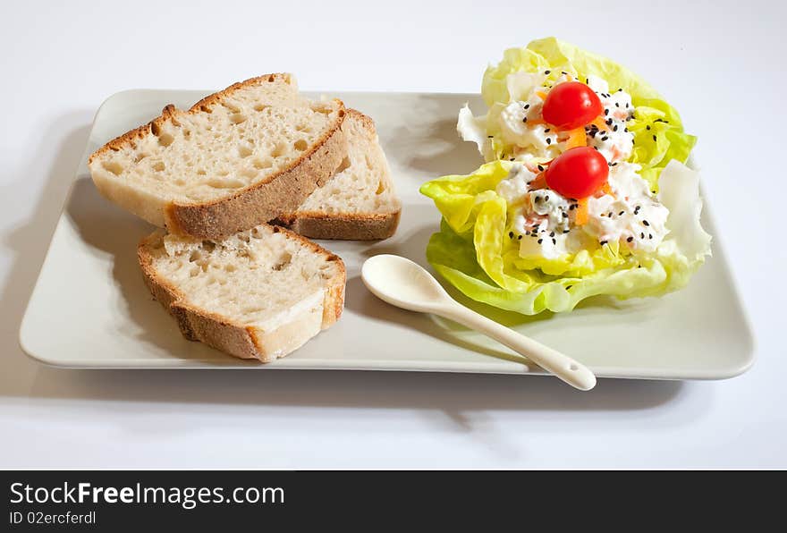 Russian salad plate with bread, lettuce and tomatoes on a saucer. Russian salad plate with bread, lettuce and tomatoes on a saucer