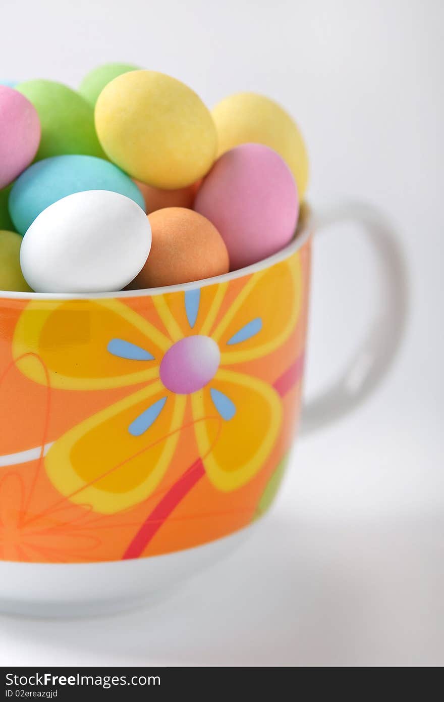 Cup full of colored easter eggs on a white background. Cup full of colored easter eggs on a white background