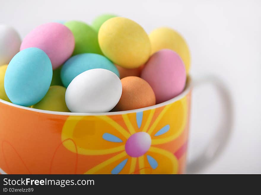 Cup full of colored easter eggs on a white background. Cup full of colored easter eggs on a white background