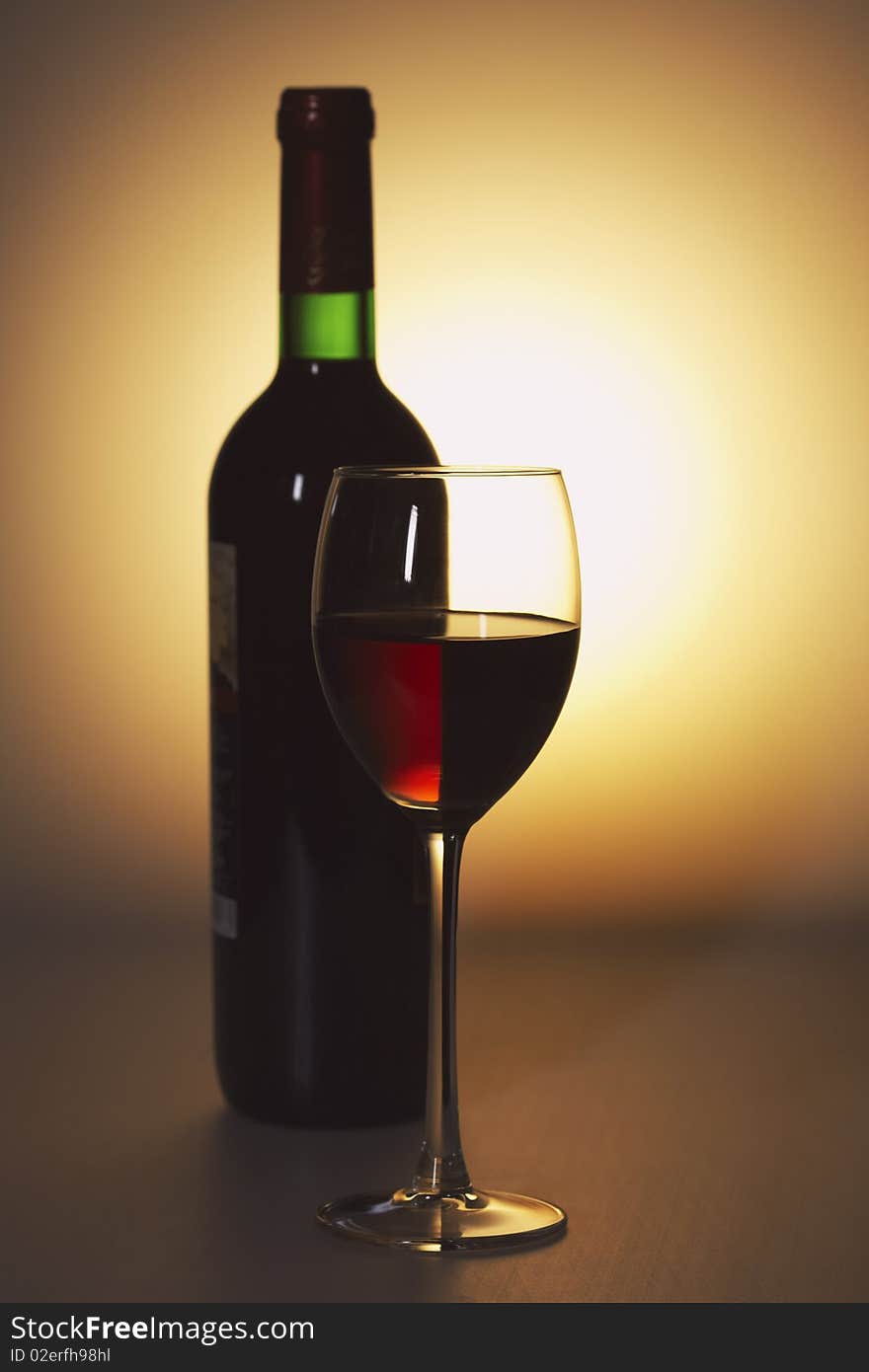 Bottle and a glass of red wine on an abstract background