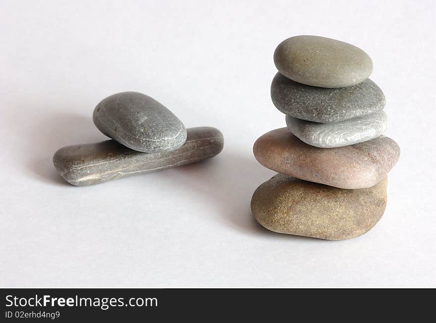 Tower of some stones over white and two stones in background