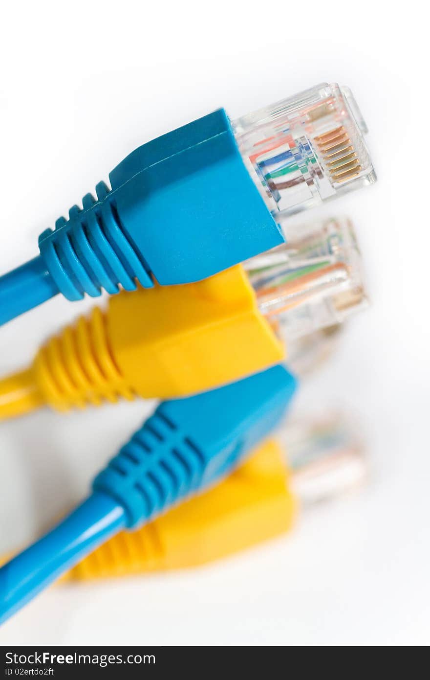 Close up shot of blue and yellow network cables on white background.