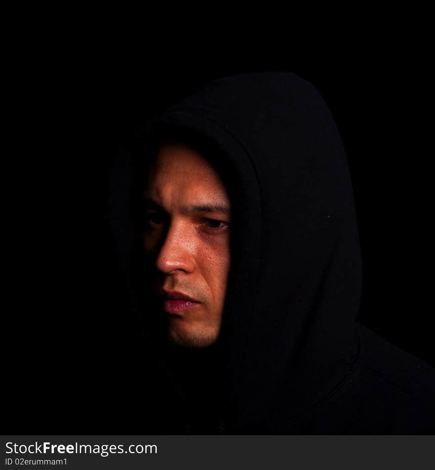 Stylish young man with hoddie over a black background.