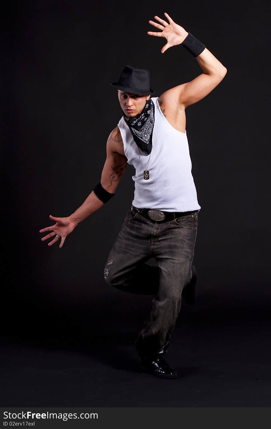 Young stylish asian dancer in front of black background moving to hip jop music. Young stylish asian dancer in front of black background moving to hip jop music.