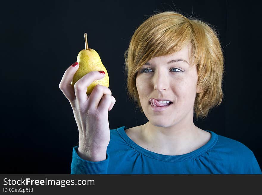 Cute young blond girl holding a pear. Cute young blond girl holding a pear