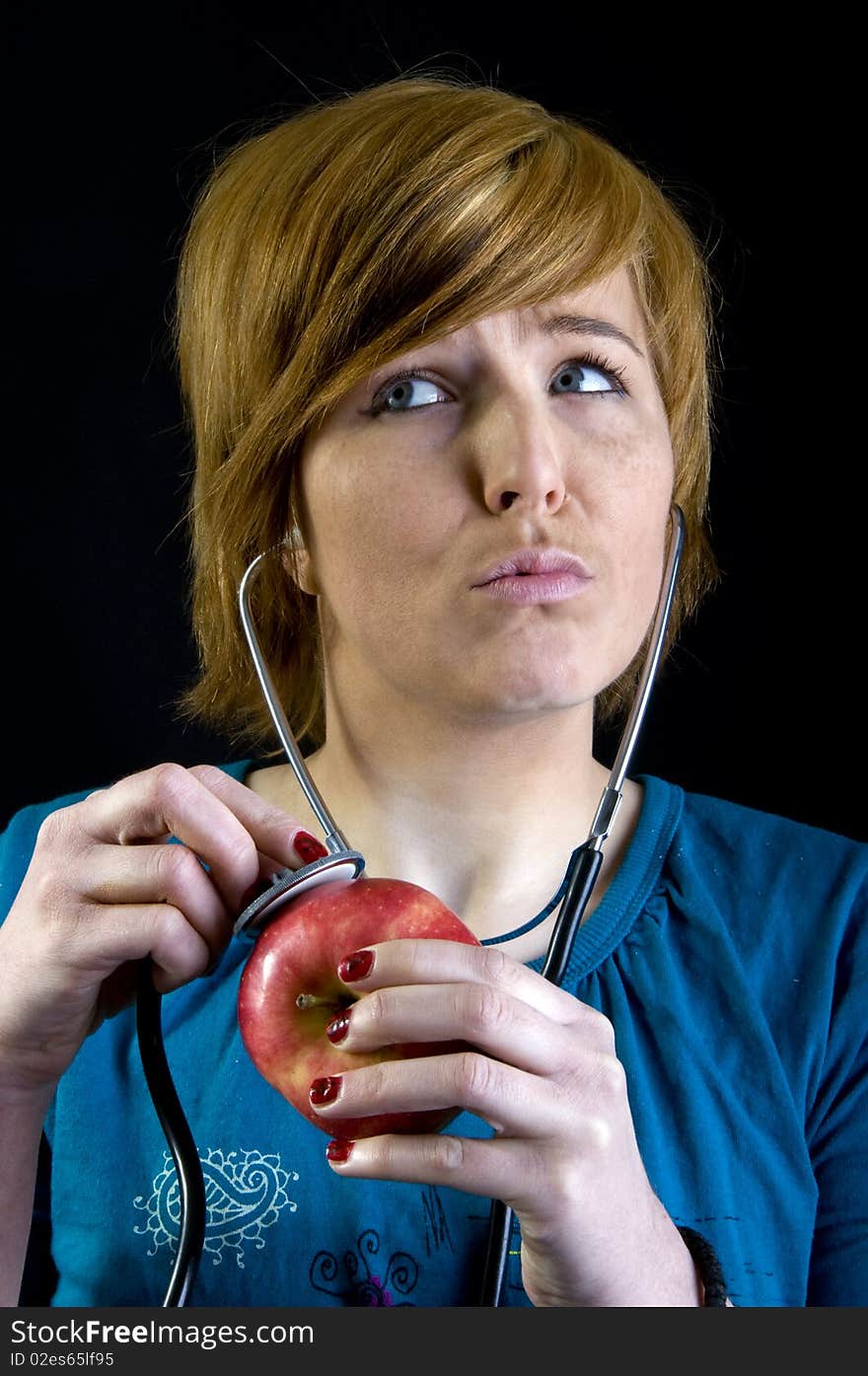 Cute young blond girl is checking her apple. Cute young blond girl is checking her apple