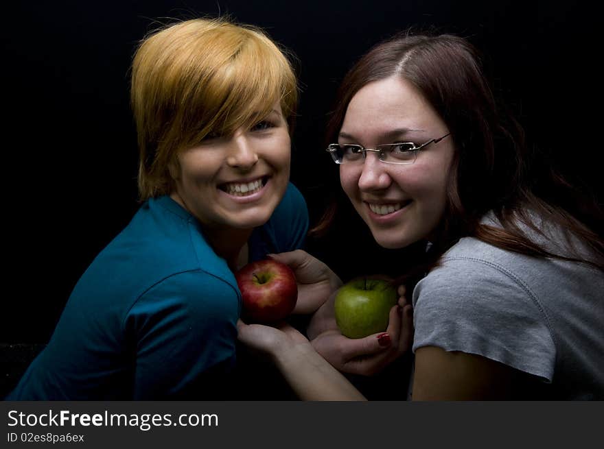 Two teen girls holding apples. Two teen girls holding apples