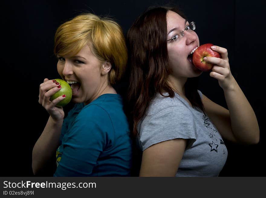 Two girls eating fresh fruits