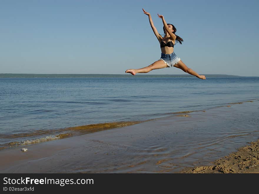 Girl jumping on the river bank. Girl jumping on the river bank.