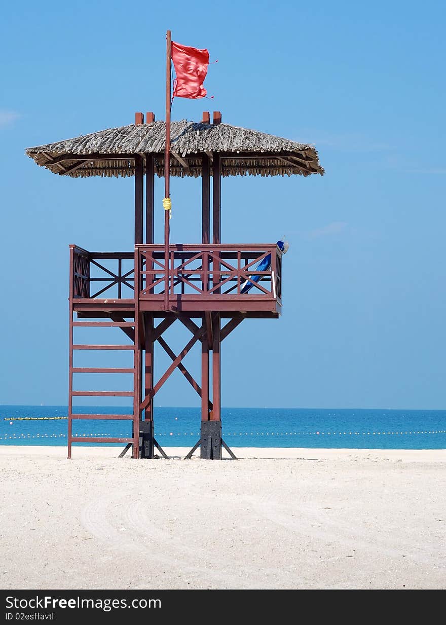 Red flag on a beach against blue sky