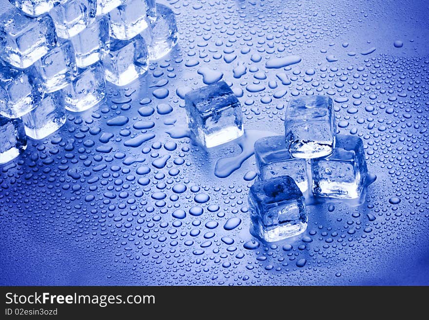 Ice cubes closeup on blue background with bubbles