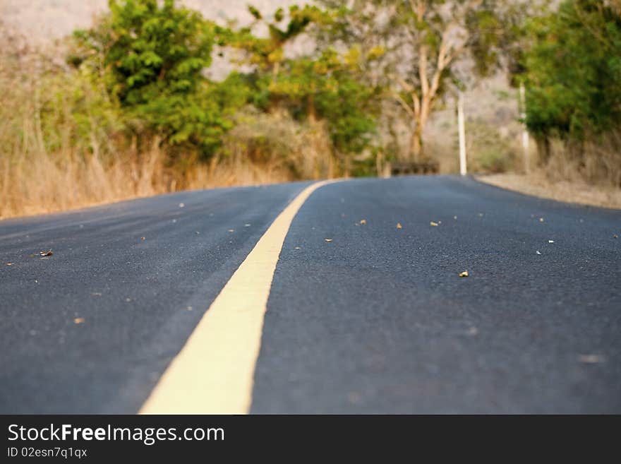 Road with single dividing yellow line close up with