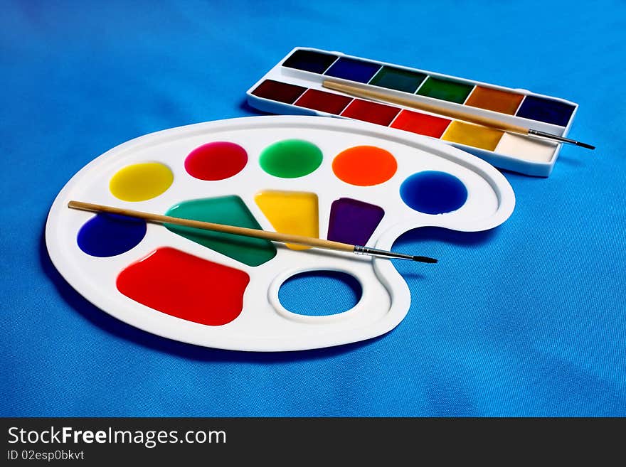 Paints palette for drawing isolated on blue background. Paints palette for drawing isolated on blue background