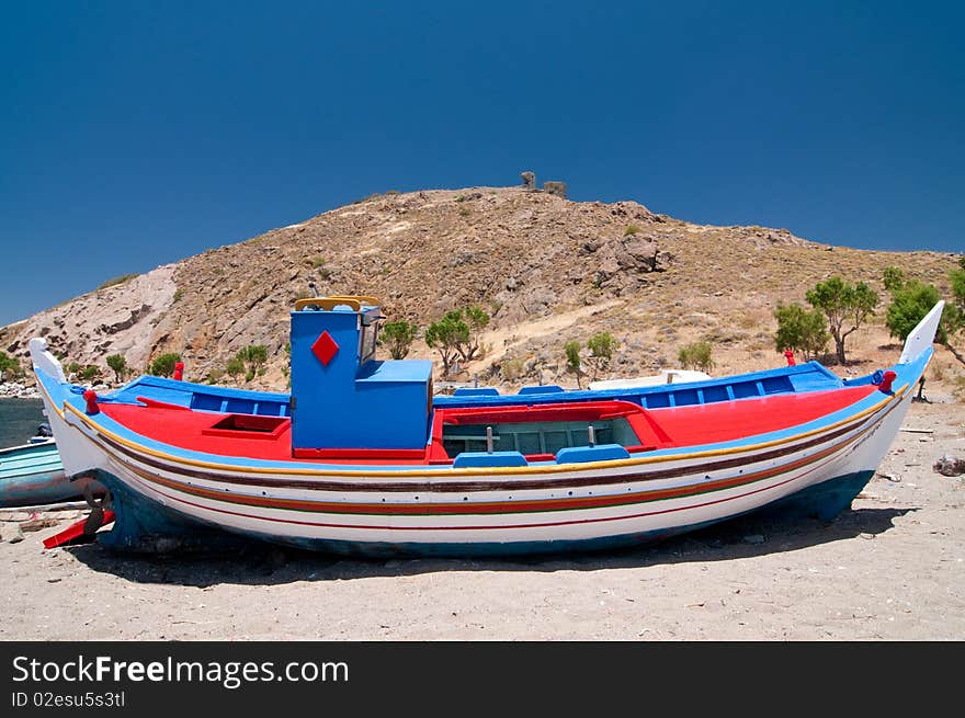 Small colourful fishing boat being repaired