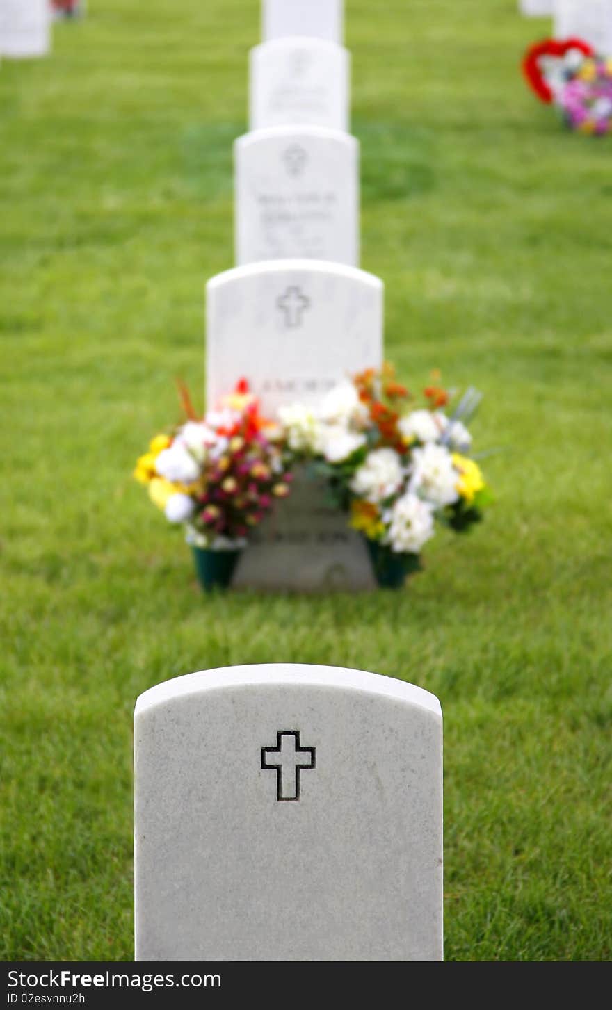 White granite headstones with crosses mark the graves of fallen soldiers at the Fort Logan National Cemetery in Colorado, USA (shallow depth of field). White granite headstones with crosses mark the graves of fallen soldiers at the Fort Logan National Cemetery in Colorado, USA (shallow depth of field).