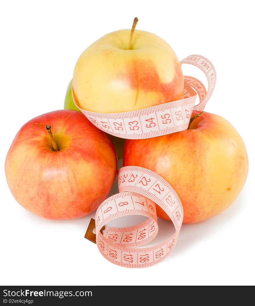 Pink measuring tape and some apples on a white background