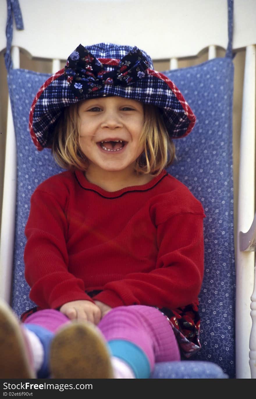 Cute little girl sitting in a white chair. Cute little girl sitting in a white chair