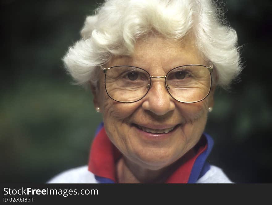 Senior woman with white hair and glasses