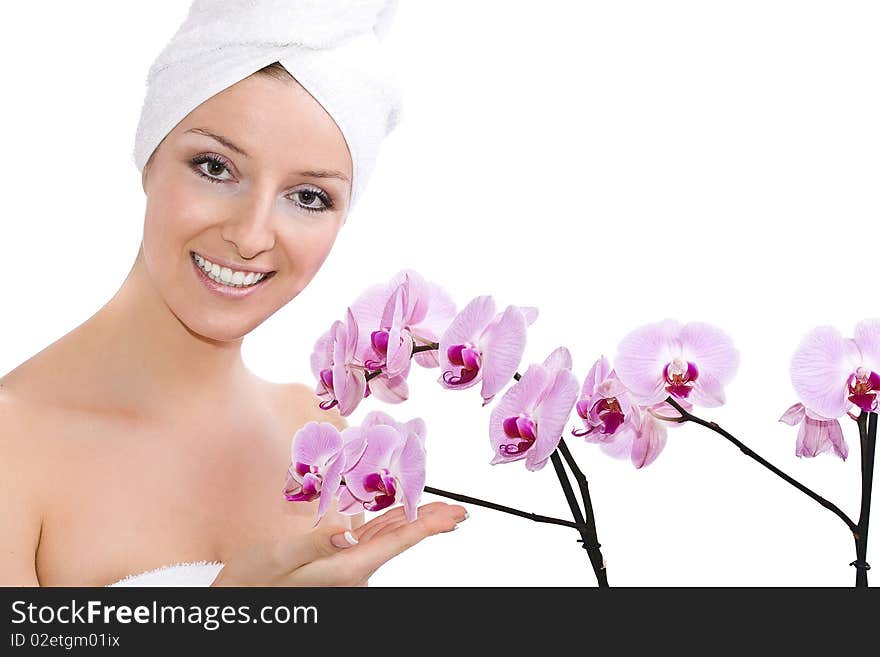 Woman with towel on head, after bath holding violet orchid flowers on hand. Woman with towel on head, after bath holding violet orchid flowers on hand