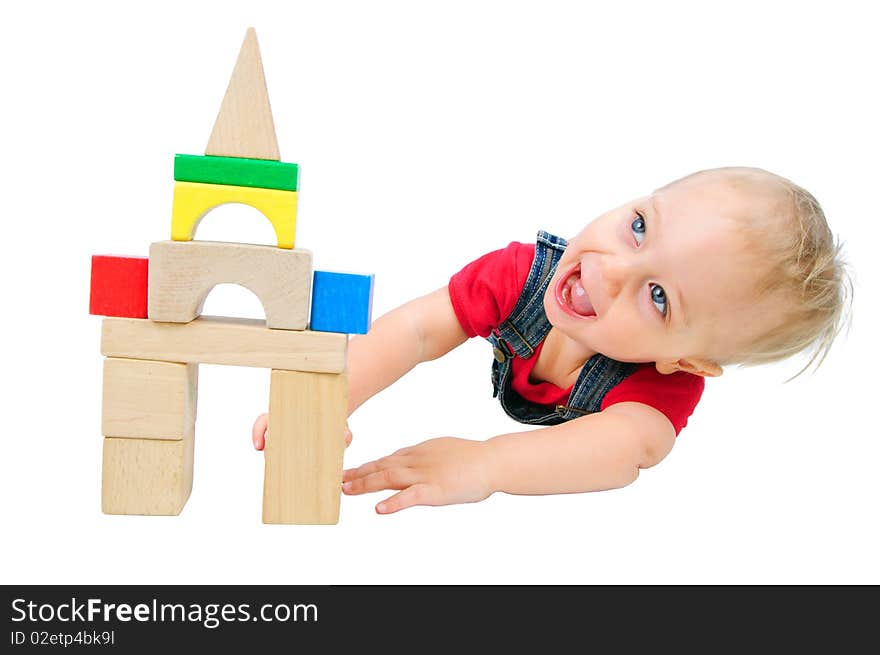 Little cute boy builds houses out of colored blocks. Little cute boy builds houses out of colored blocks