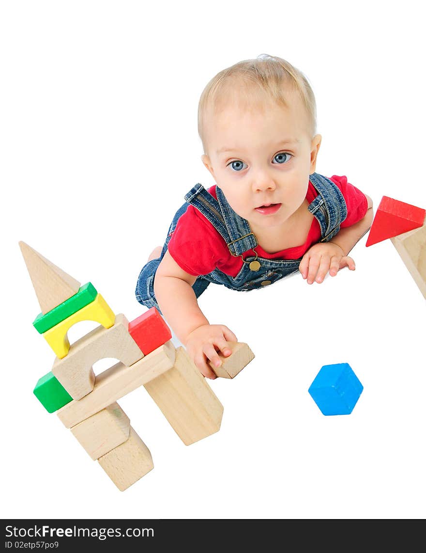 Little cute boy builds houses out of colored blocks. Little cute boy builds houses out of colored blocks